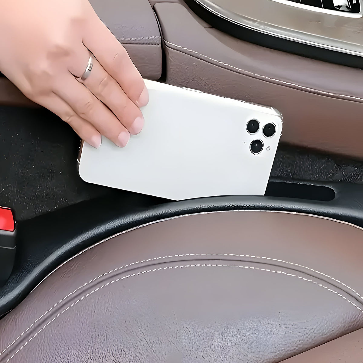 Smartphone glissé dans la fente de rangement de l'organiseur Lysora, entre le siège et la console